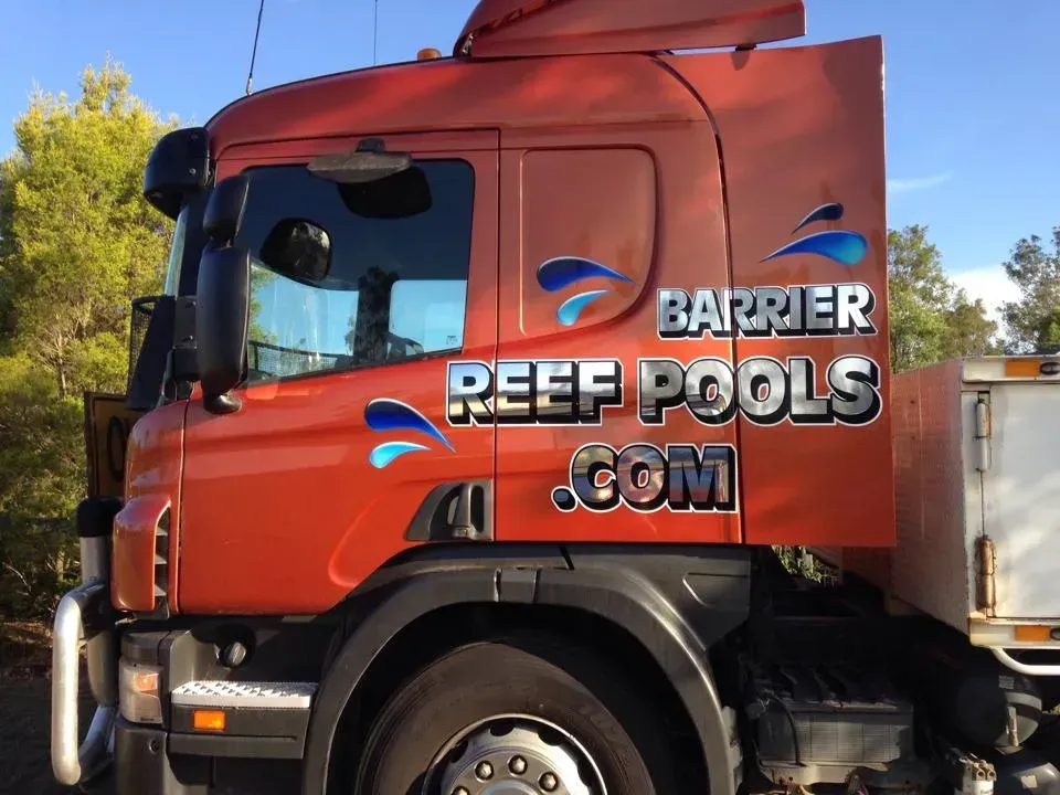 A red truck with barrier reef pools written on the side