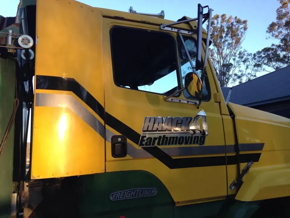 A yellow truck with the word earthmoving on it