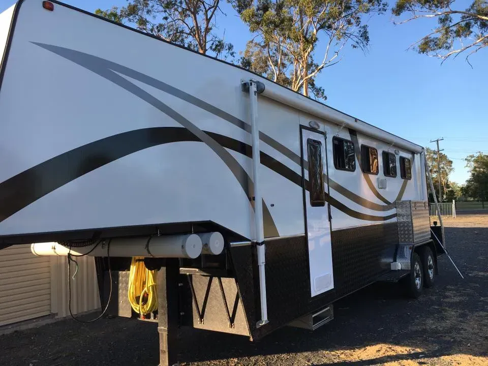A white and black trailer is parked in a parking lot