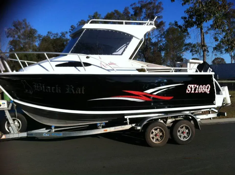 A black and white boat with the name black rat on it