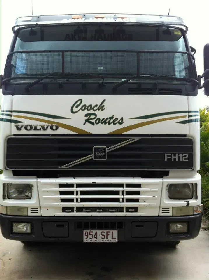 A white volvo truck with coach routes written on the front