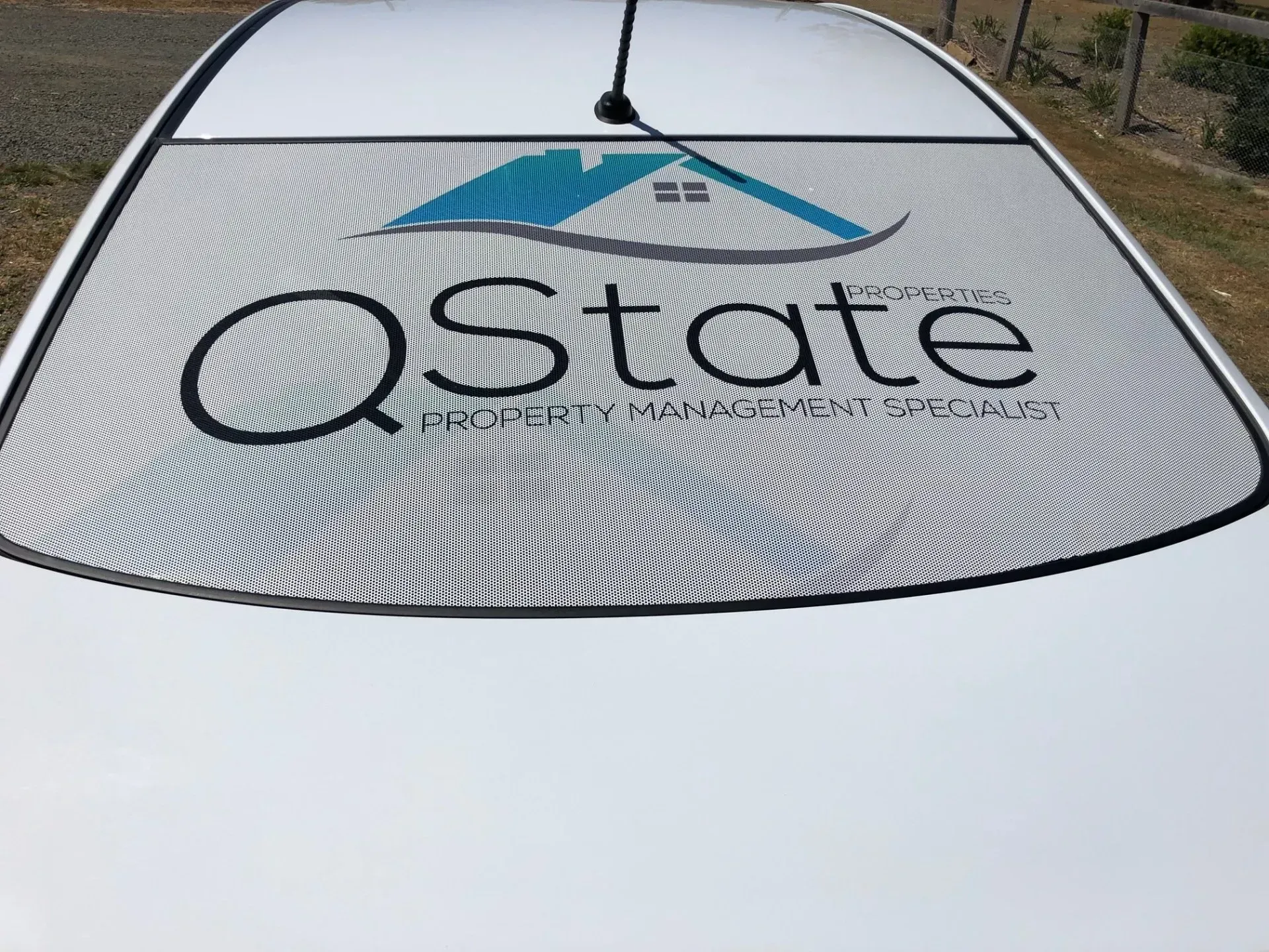 A white car with the word state on the windshield