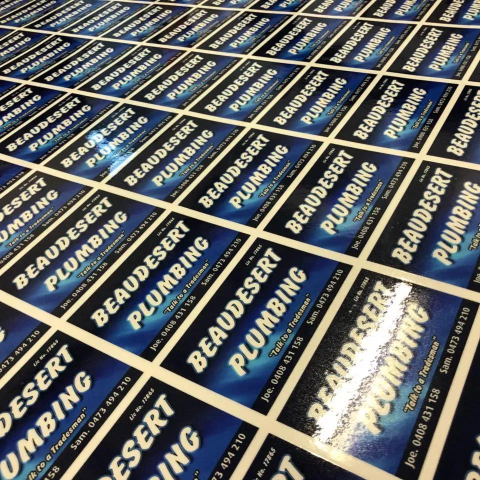 A bunch of beaudesert plumbing stickers on a table