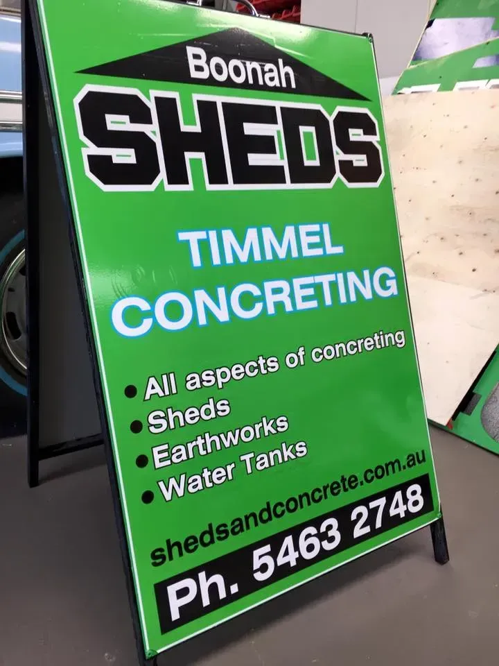 A green sign that says boonah sheds on it