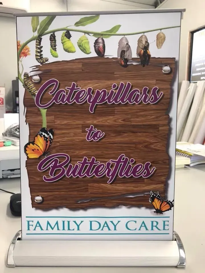 A sign that says `` caterpillars to butterflies '' is sitting on a table.