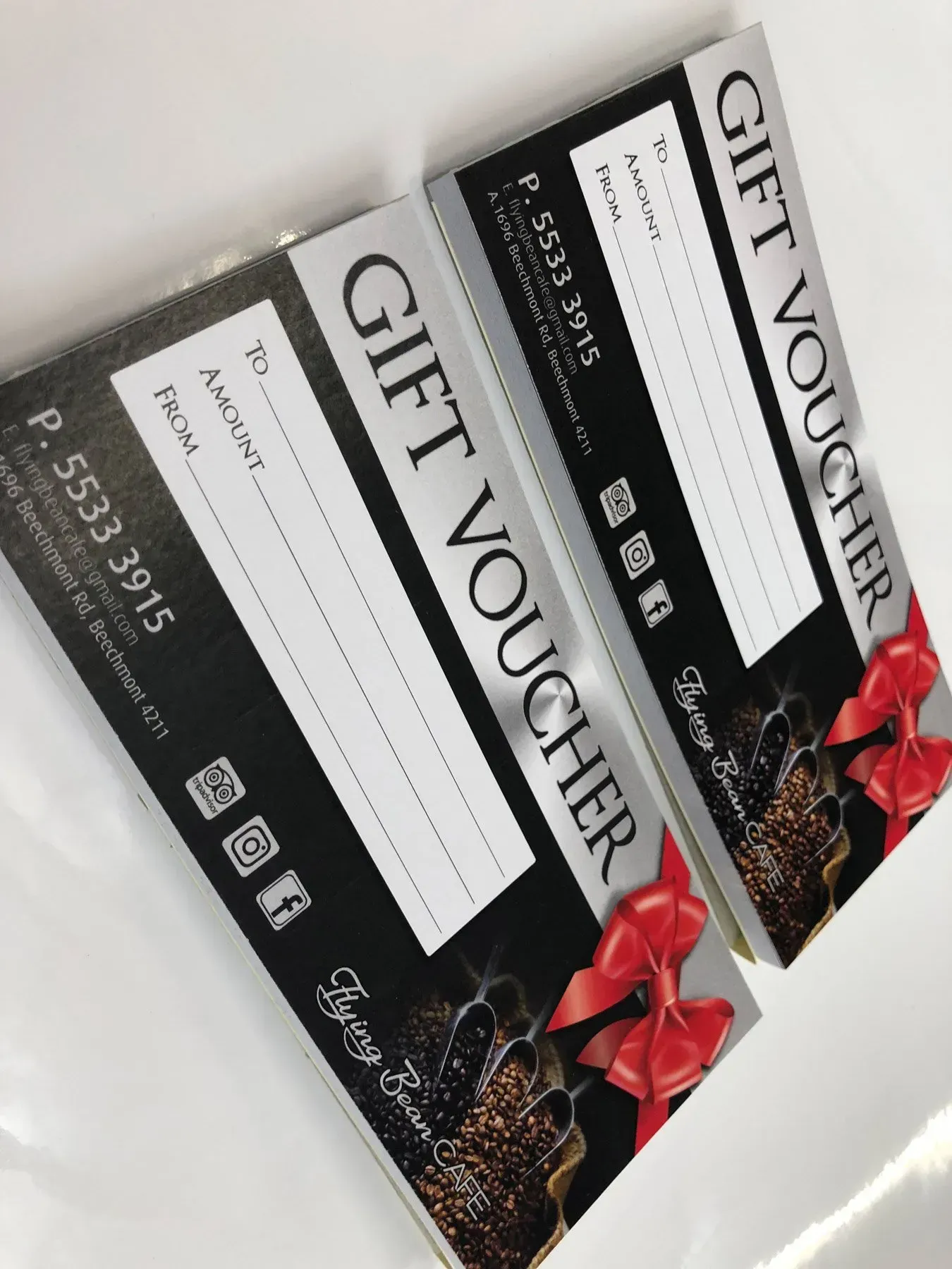 Two gift vouchers with a red bow on them