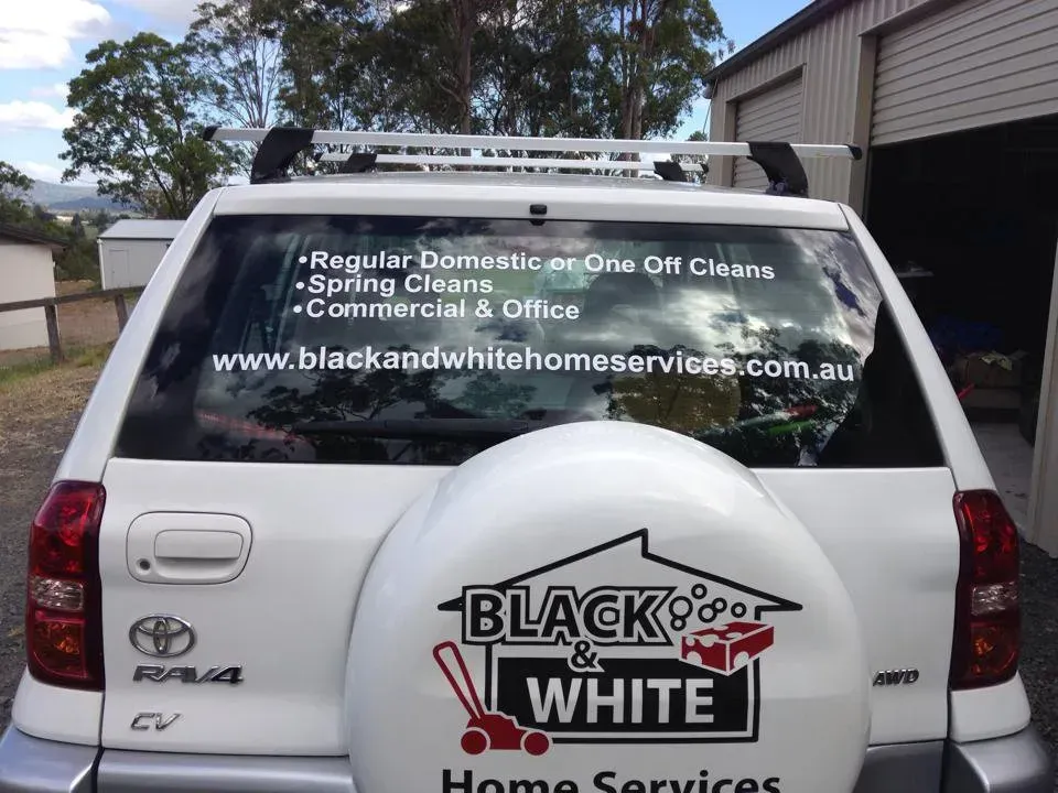A white suv with a tire cover that says black and white home services