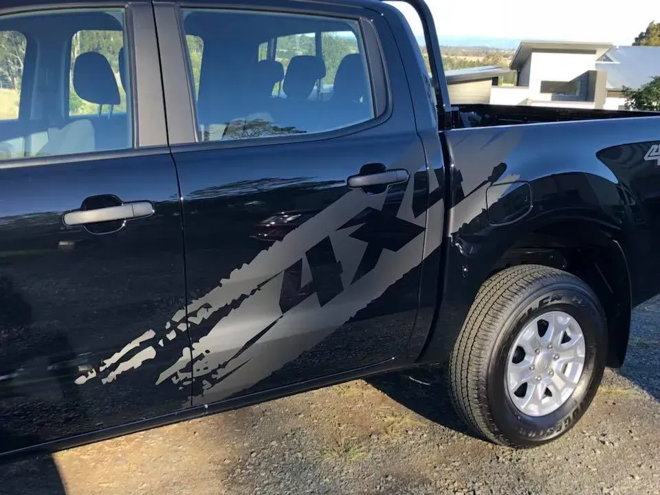 A black 4x4 truck is parked on the side of the road.