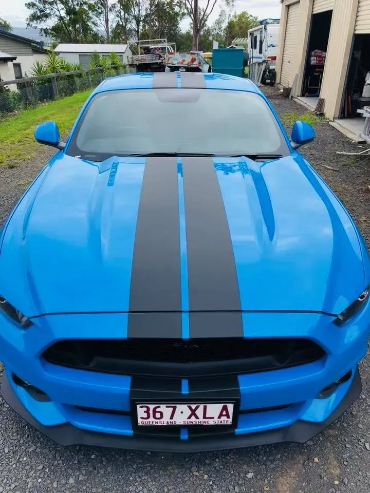 A blue mustang with a license plate that says 367 xla