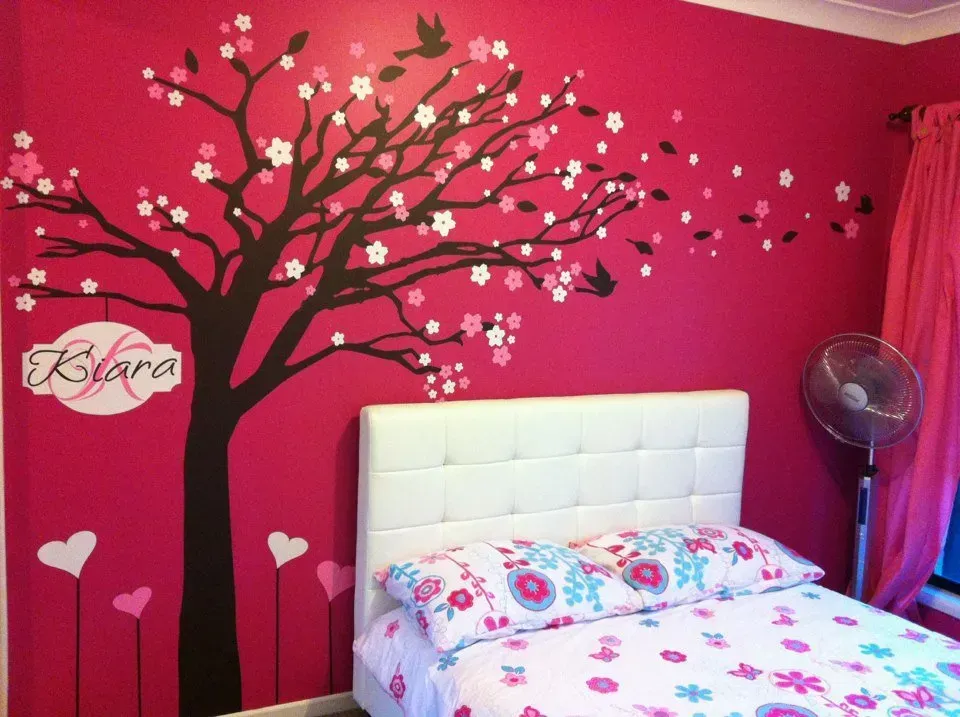 A bedroom with a tree on the wall and the name kiana