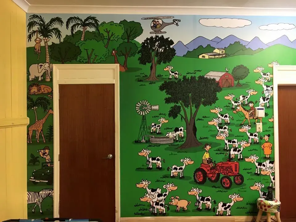 A room with a mural of animals and a tractor on the wall