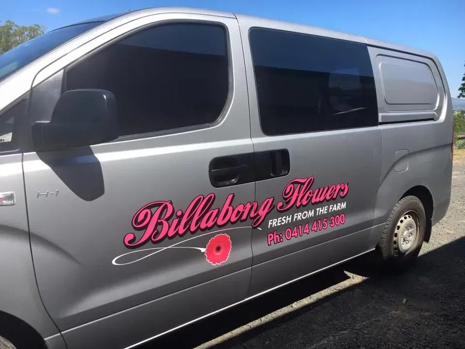 A billabong flowers van is parked in a parking lot