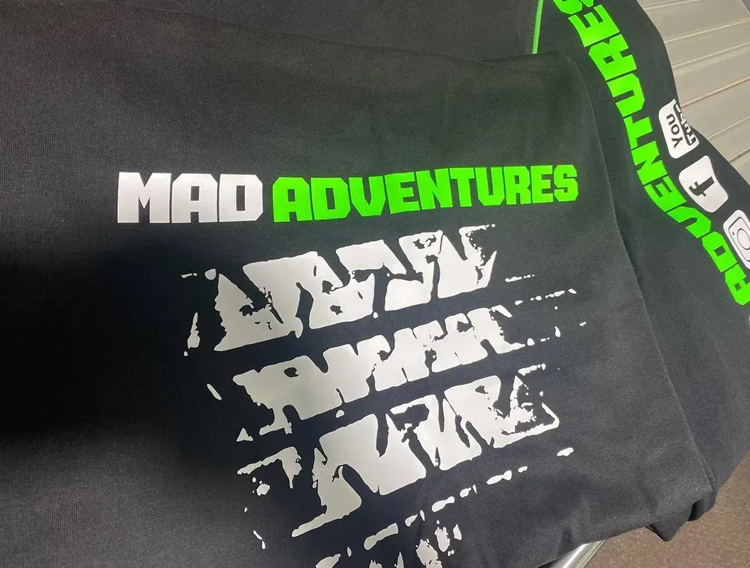 A black shirt that says mad adventures on it