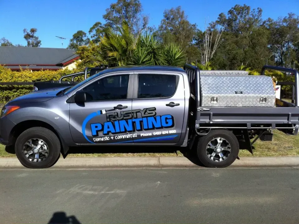 A painting truck is parked on the side of the road
