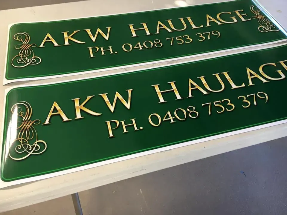 Two green signs that say akw haulage on them