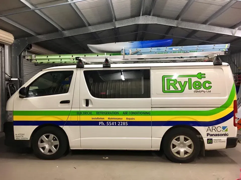 A white van with the word rylec on the side is parked in a garage.