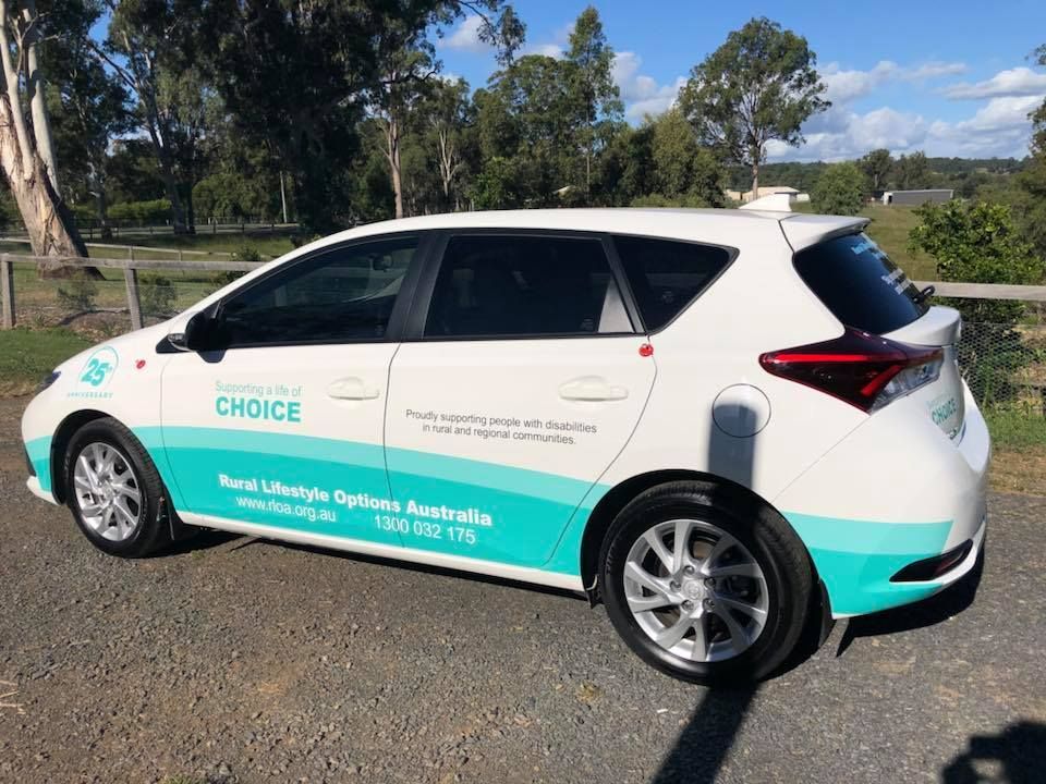 A white and green car is parked on the side of the road.