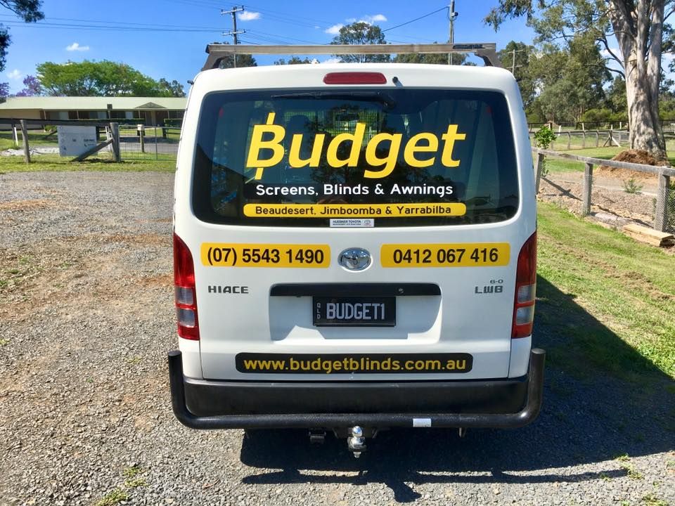A white van with the word budget on the back window