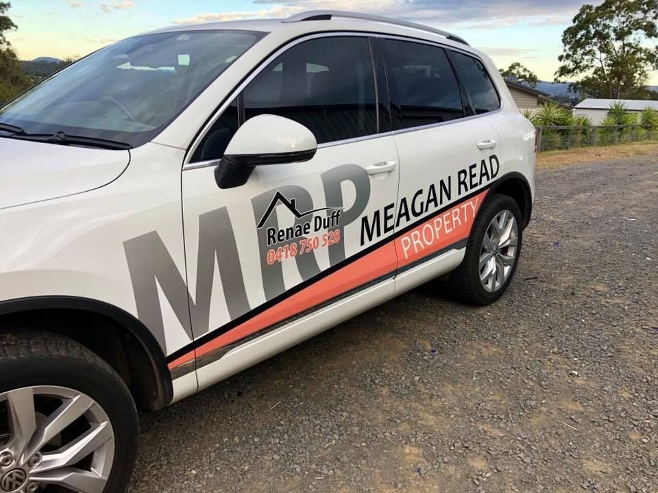 A white car with the word meagan read on the side