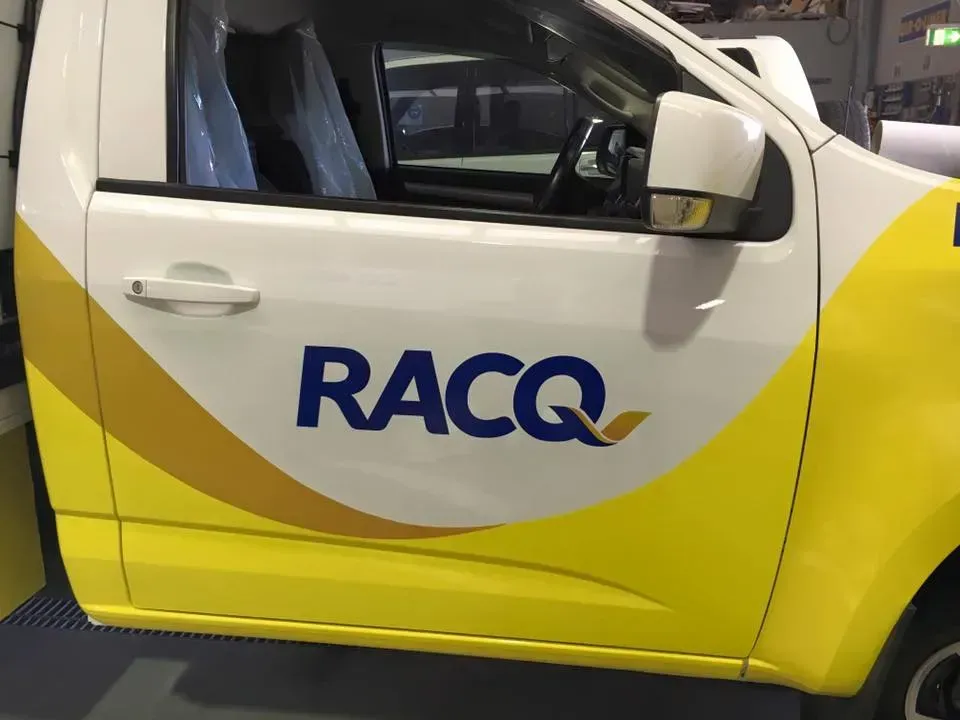 A yellow and white truck with the word racq on it