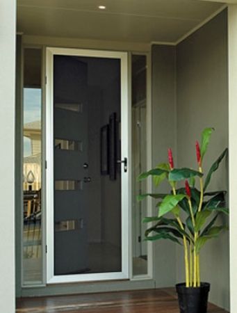 White framed screen door on a grey house with a plant next to it.