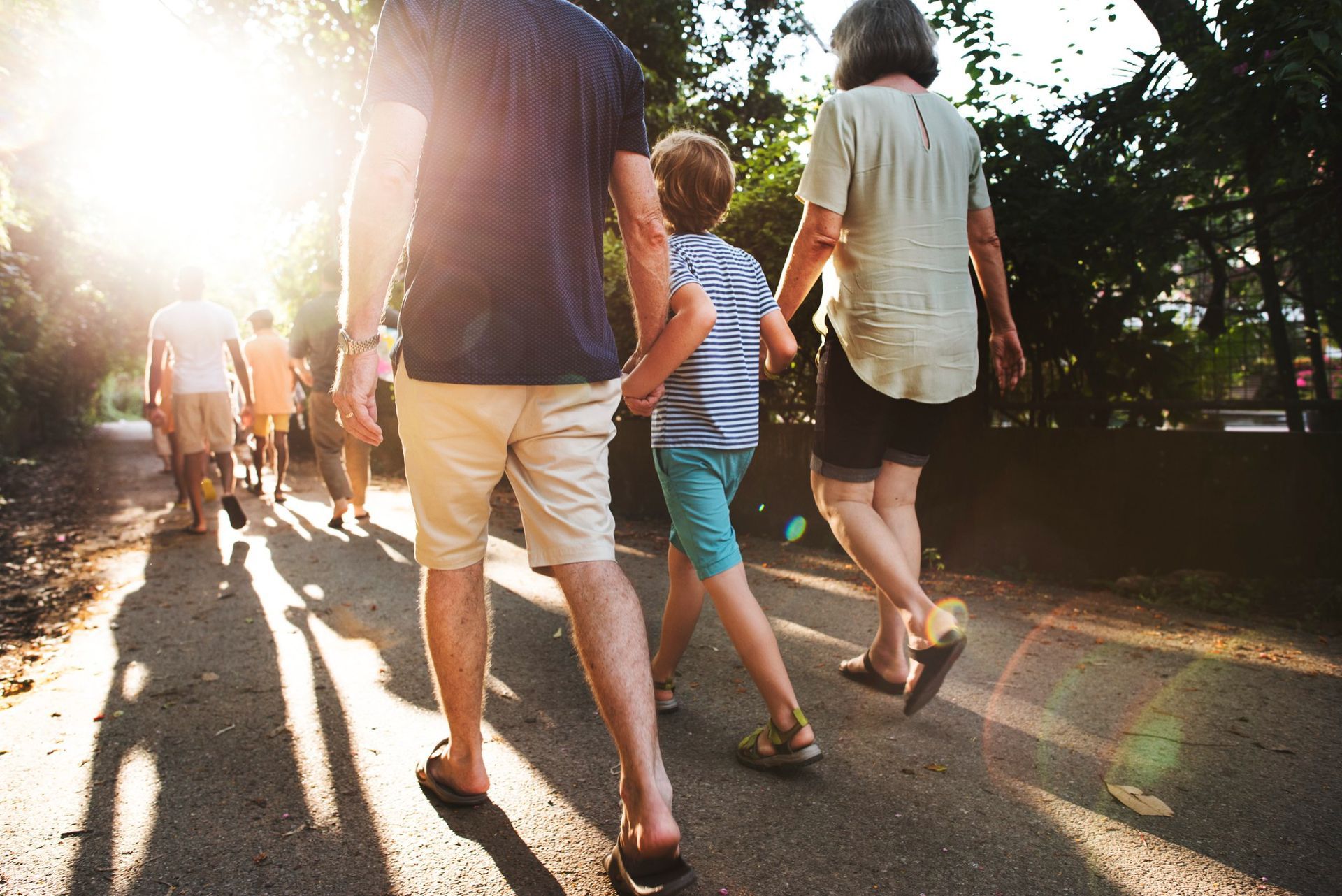 A group of people are walking down a path holding hands.