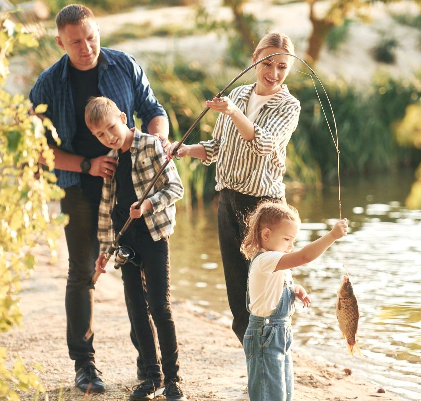 A family is fishing on the shore of a lake.