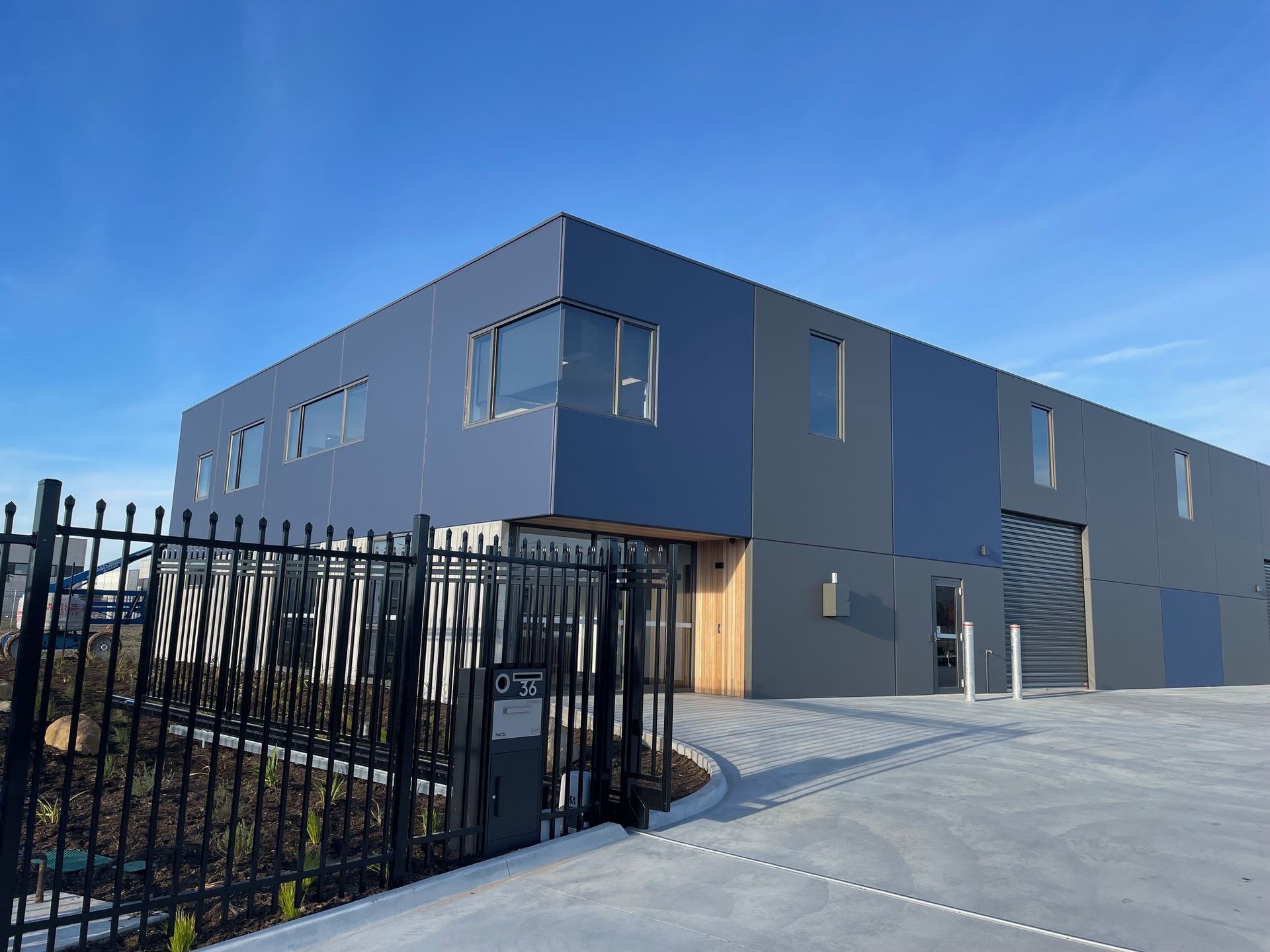 A Large Building With A Fence Around It And A Blue Sky In The Background – Cambridge, TAS - Bennett Construction (TAS)