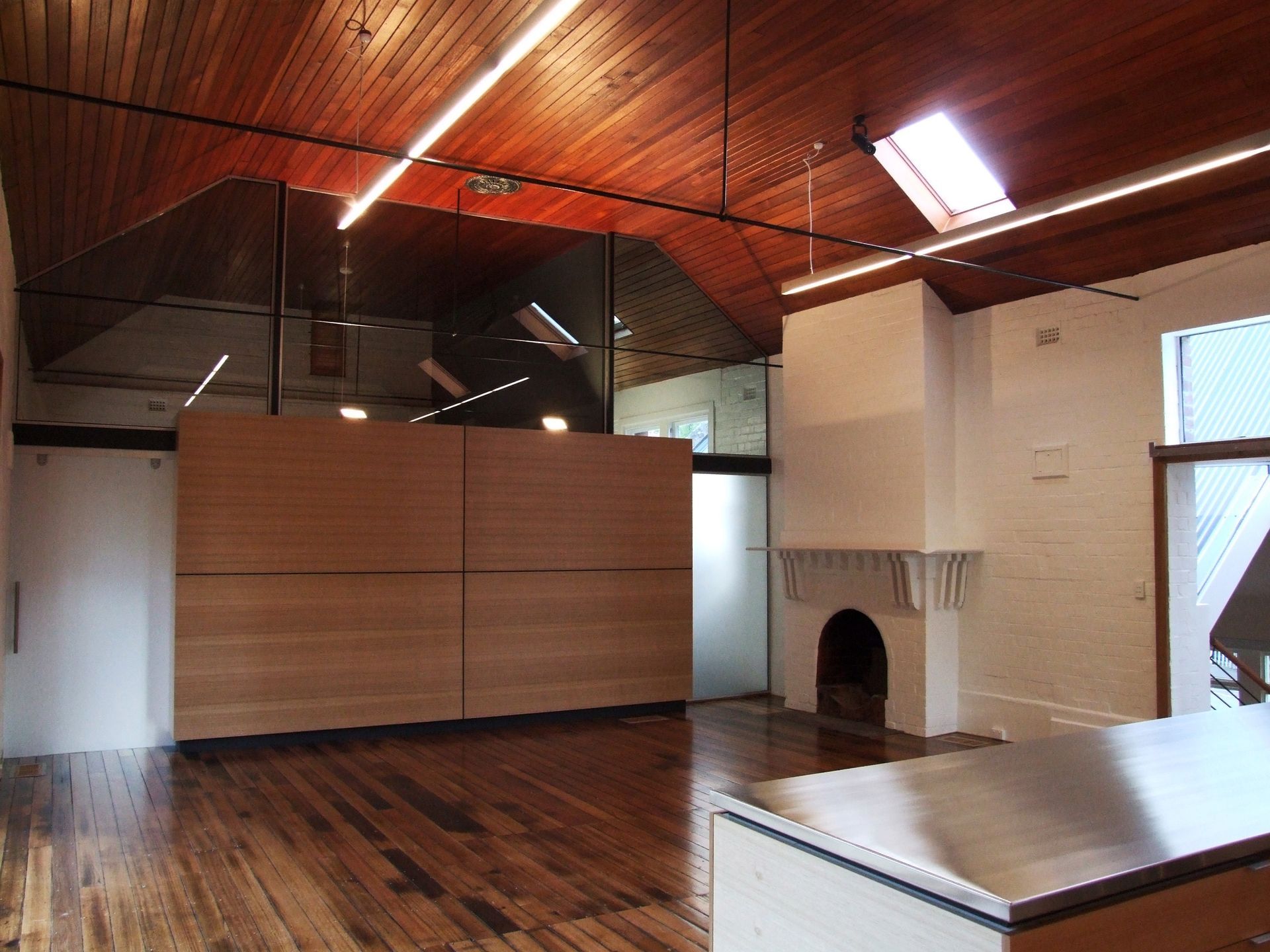 An Empty Room With Wooden Floors And A Fireplace – Cambridge, TAS - Bennett Construction (TAS)