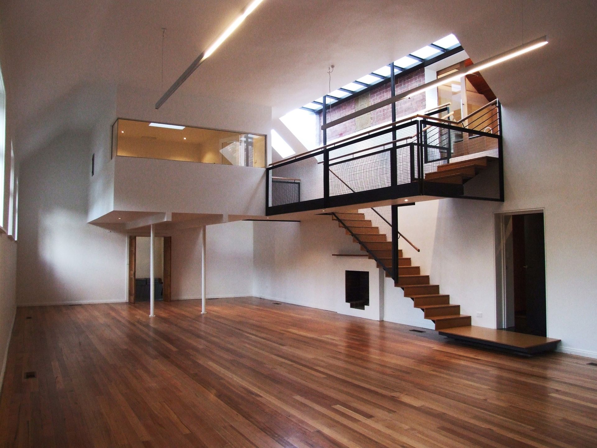 An Empty Room With A Wooden Floor And Stairs – Cambridge, TAS - Bennett Construction (TAS)