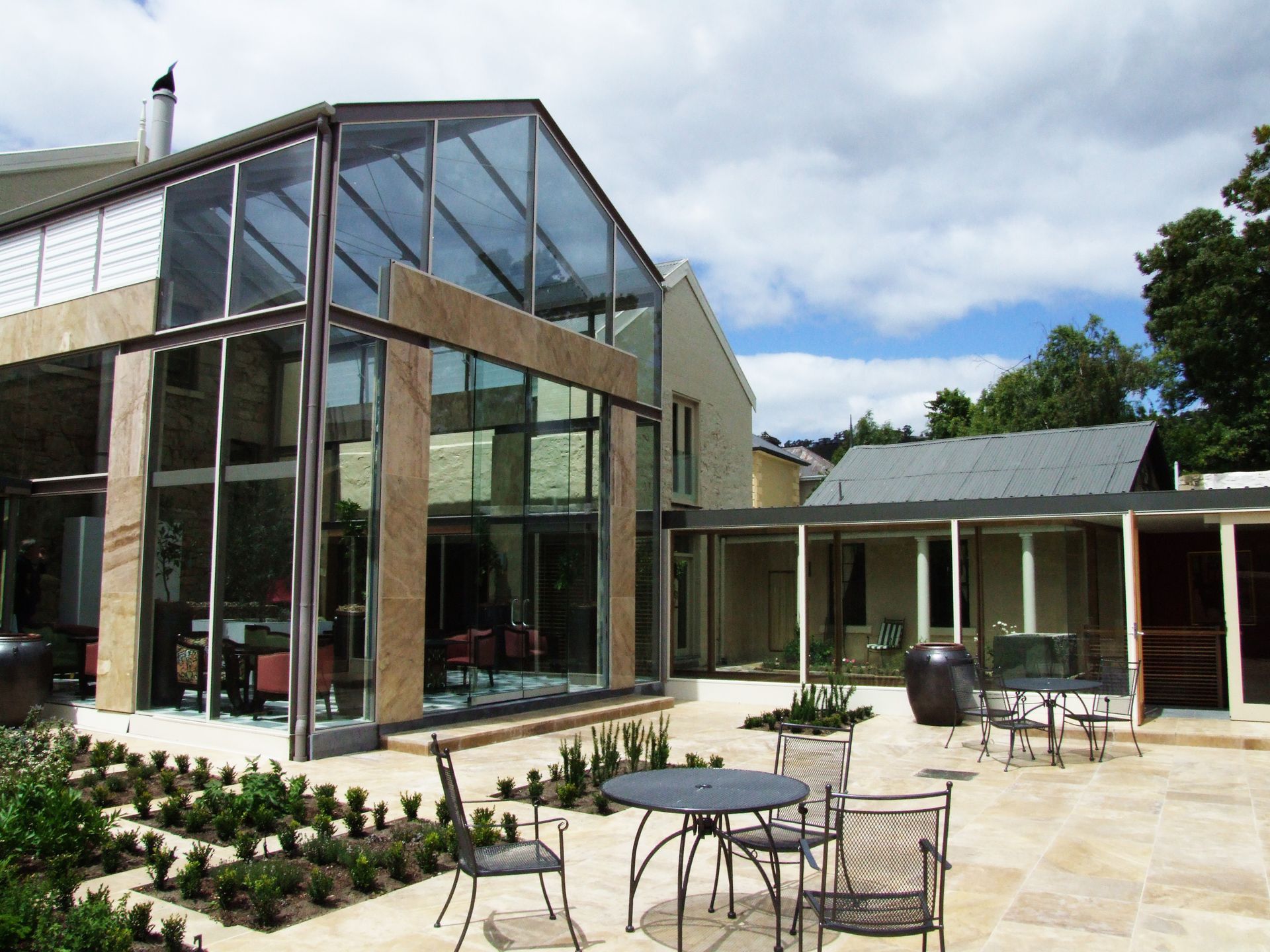 A Large Glass Building With Tables And Chairs In Front Of It – Cambridge, TAS - Bennett Construction (TAS)
