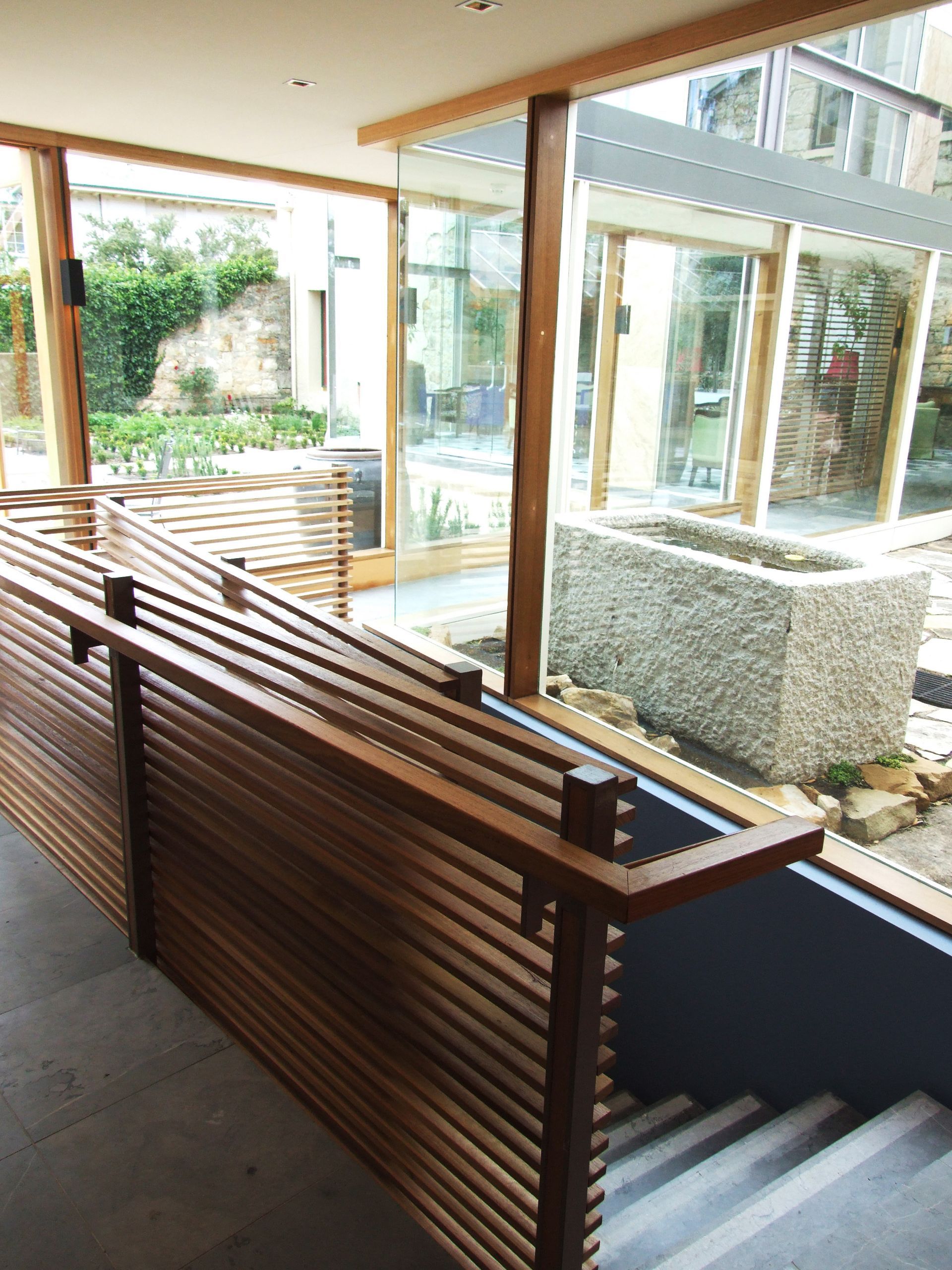 A Staircase With A Wooden Railing And A Large Window – Cambridge, TAS - Bennett Construction (TAS)