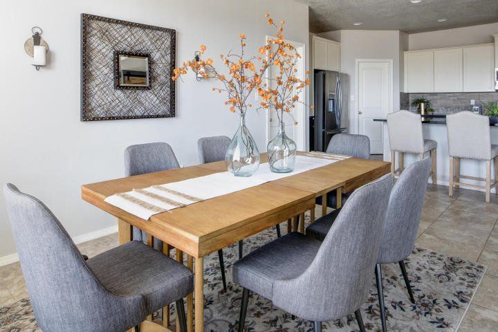A dining room with a wooden table and gray chairs.