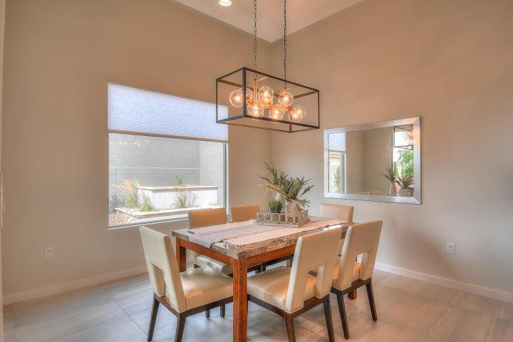 A dining room with a table and chairs and a chandelier hanging from the ceiling.