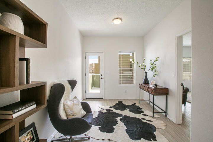 A living room with a chair and a cowhide rug.