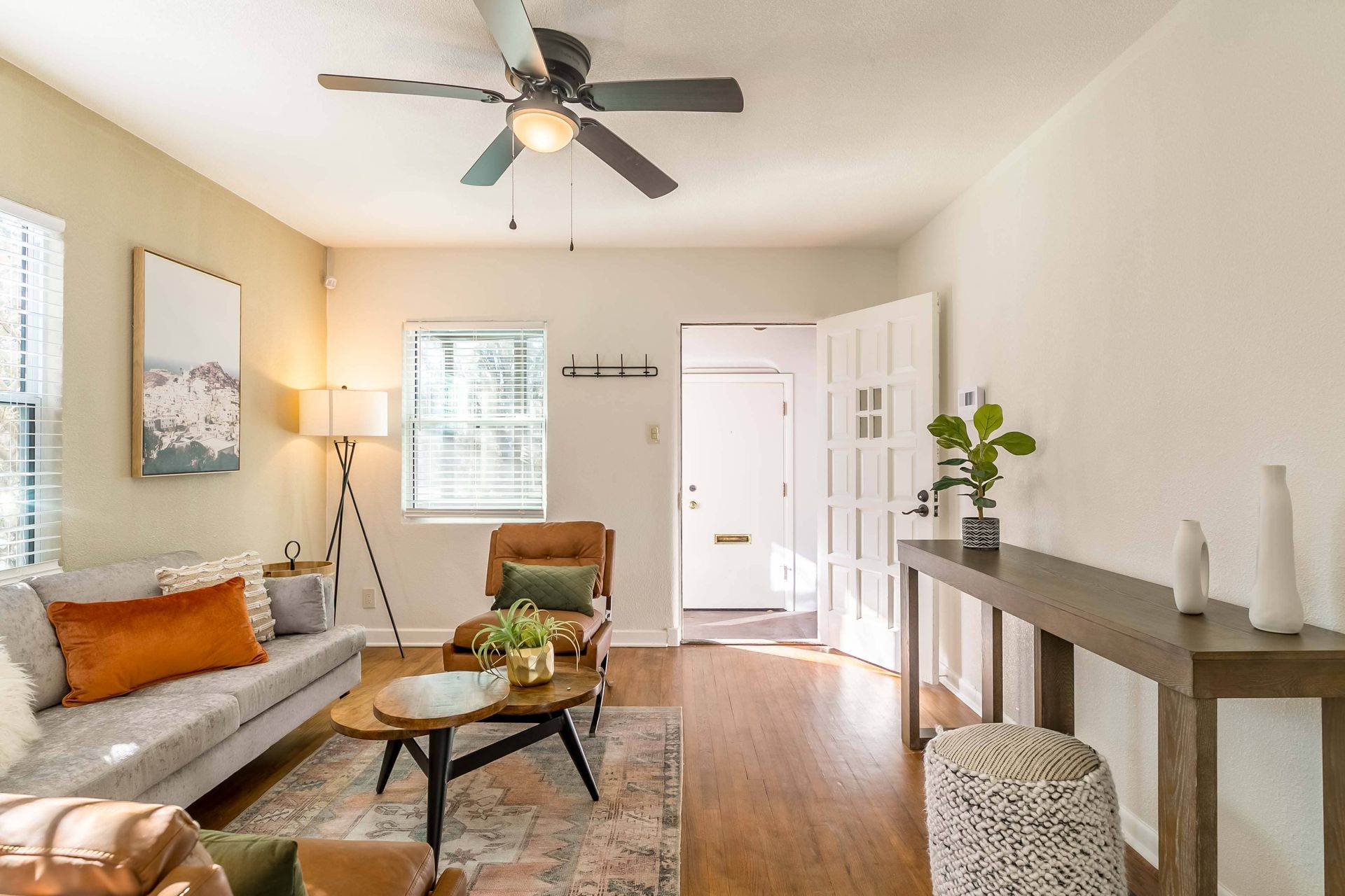 A living room filled with furniture and a ceiling fan.
