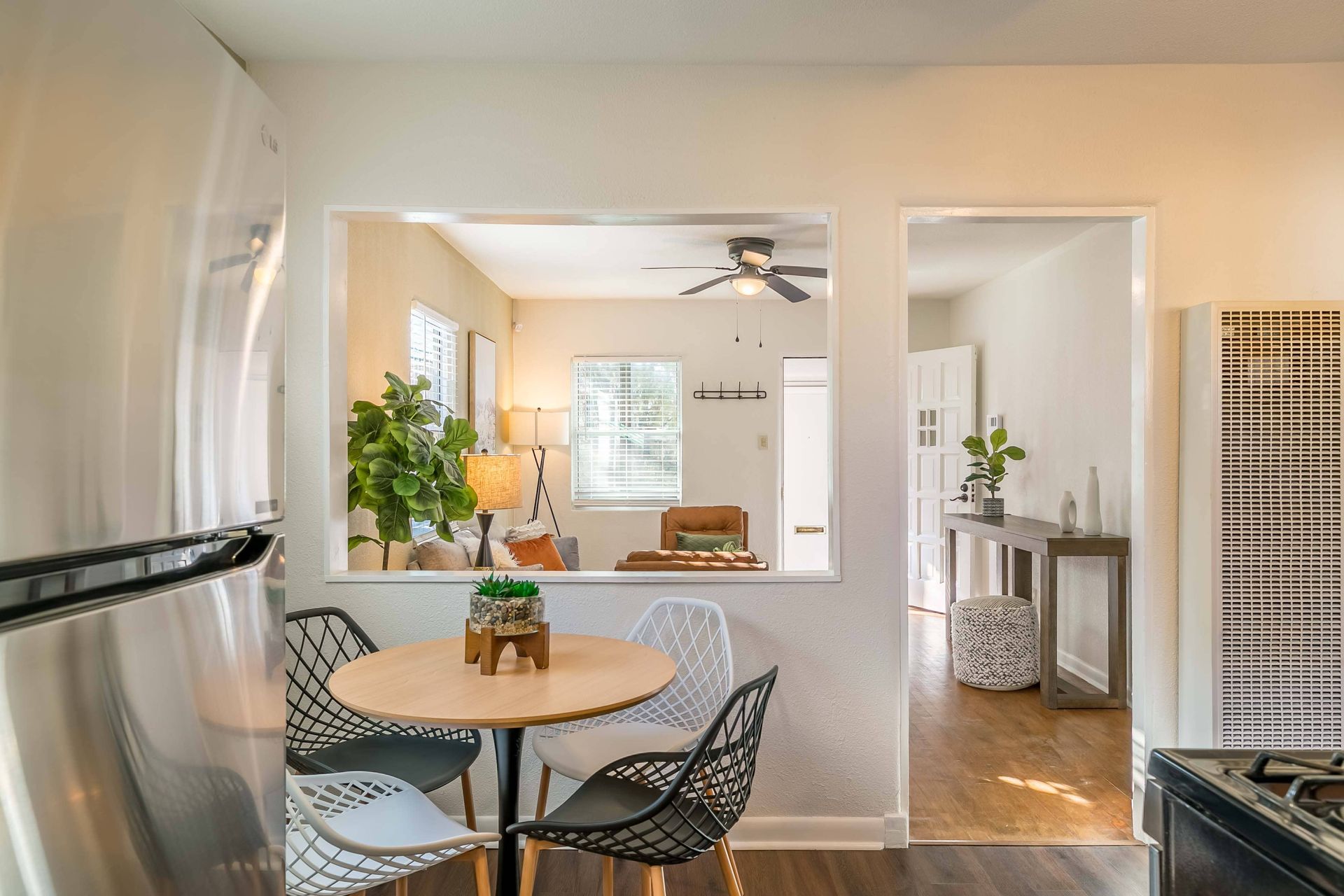 A kitchen with a round table and chairs and a stainless steel refrigerator.