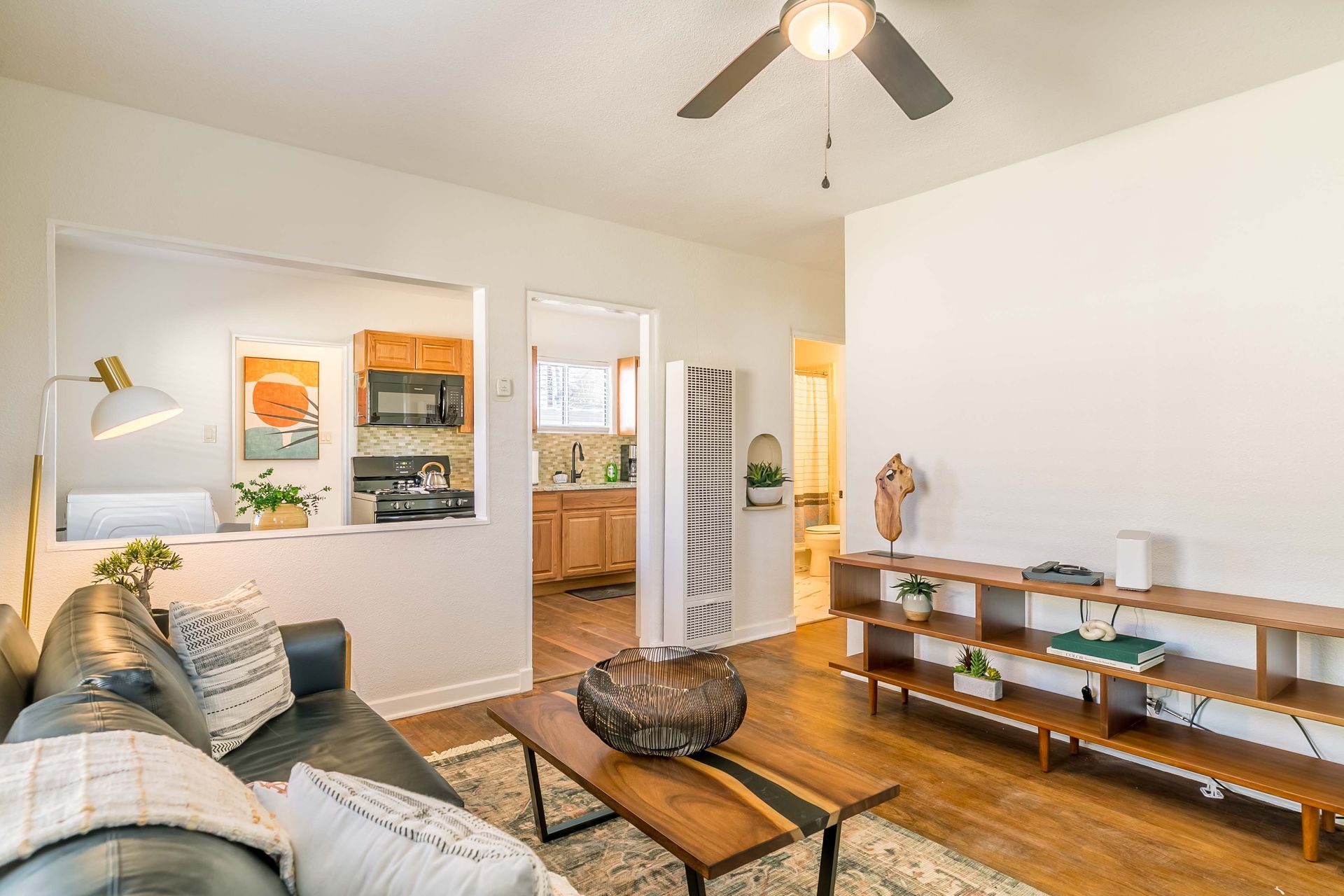 A living room with a couch , coffee table , and ceiling fan.