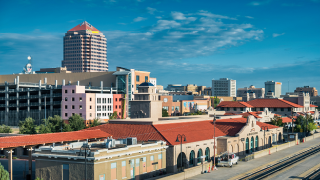 View of downtown Albuquerque, New Mexico with buildings, train depot, and blue sky.