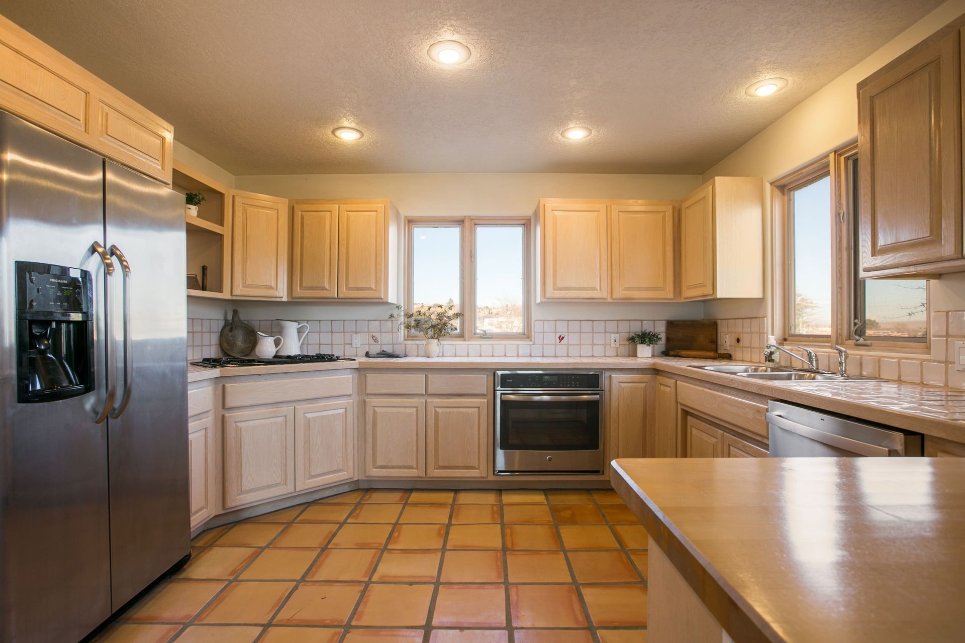 A kitchen with stainless steel appliances and wooden cabinets.