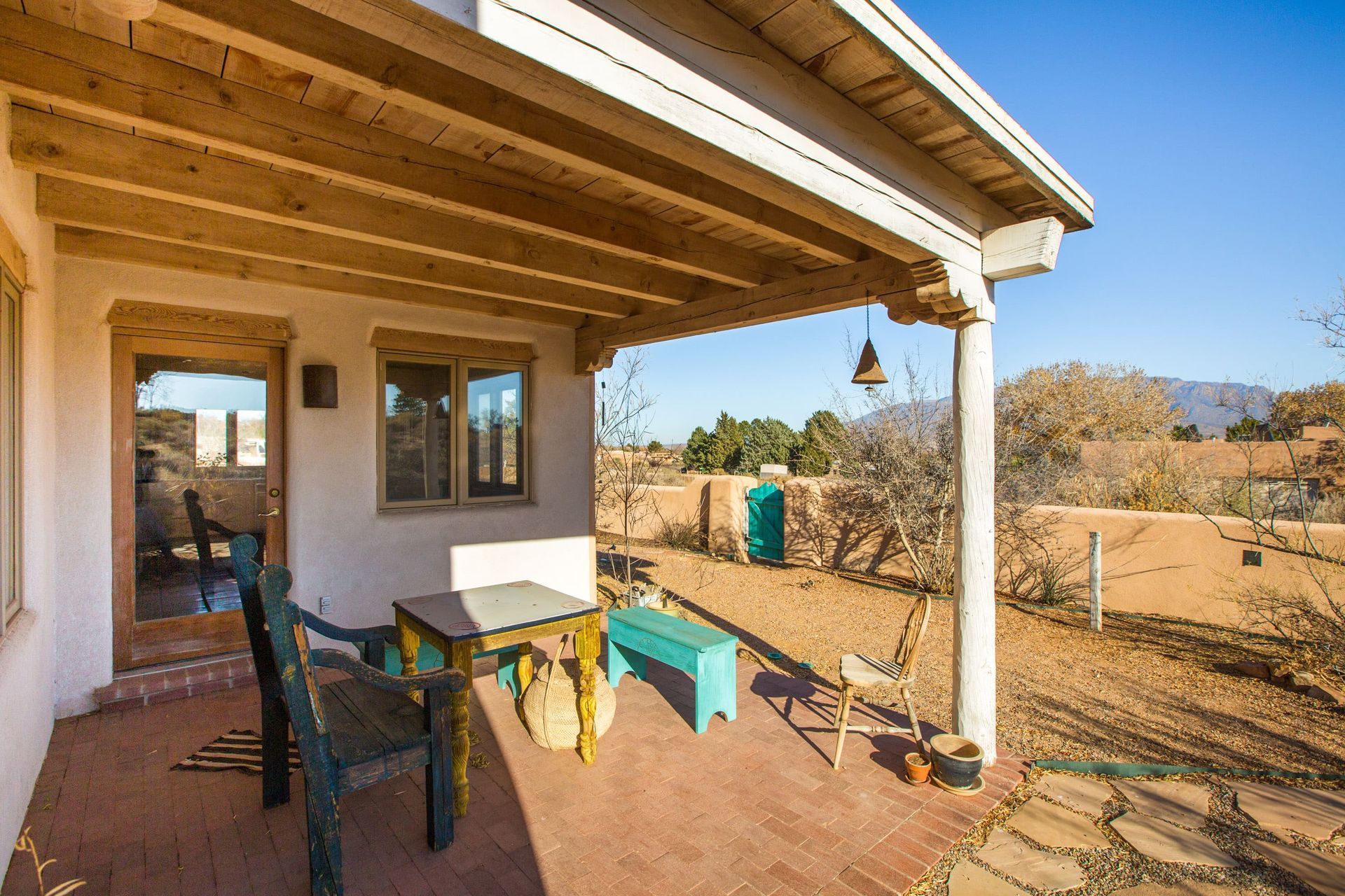 There is a porch with a table and chairs on it.