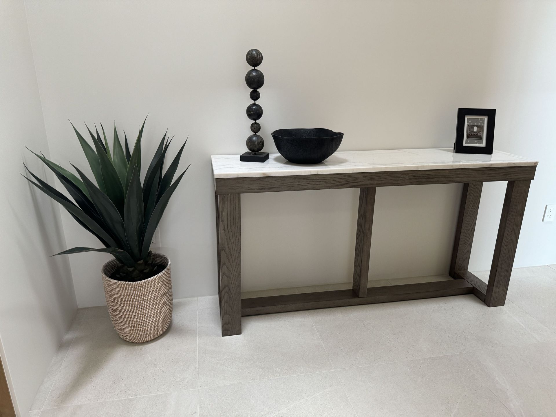 A table with a plant and a bowl on it in a room.