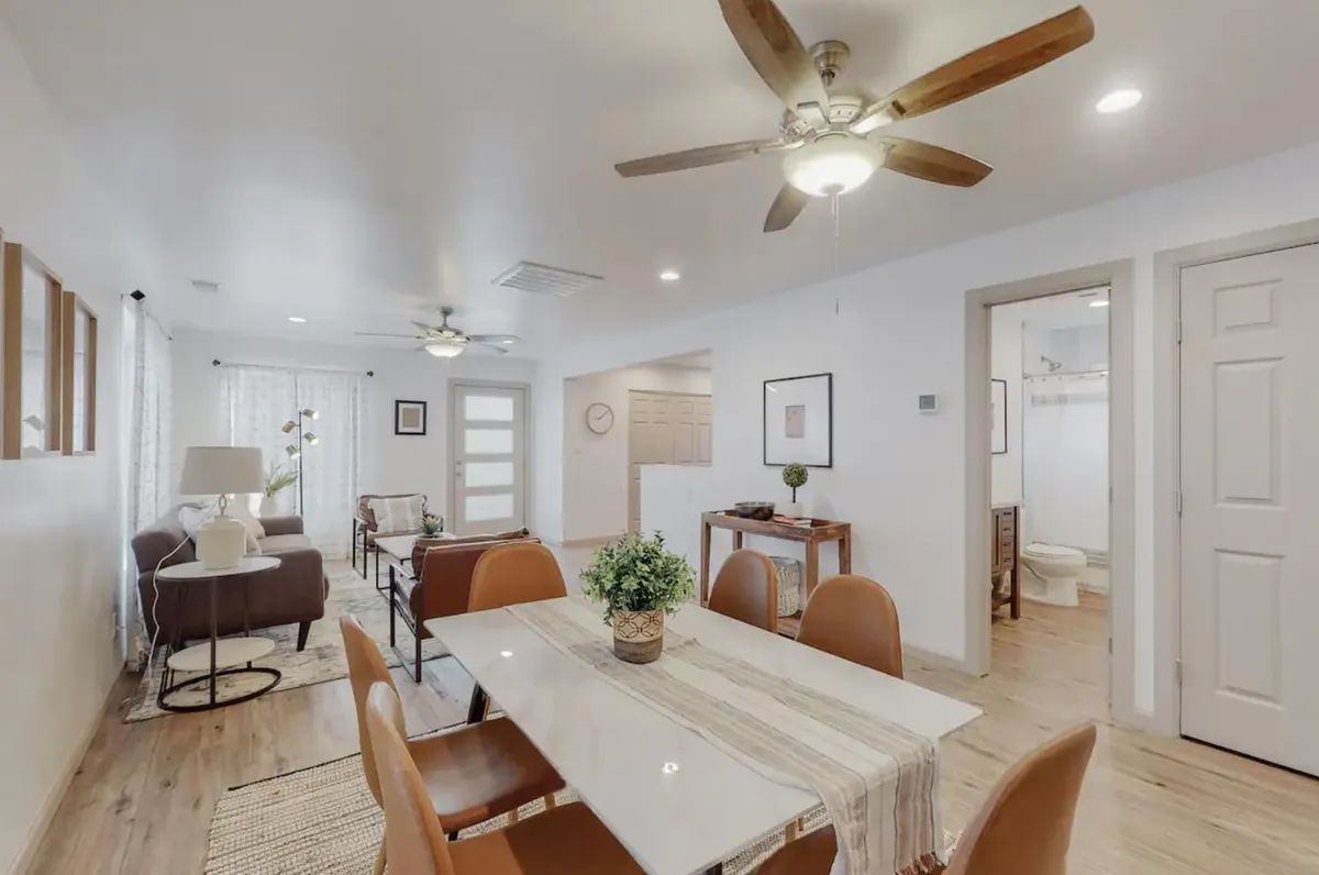 A dining room with a table and chairs and a ceiling fan.