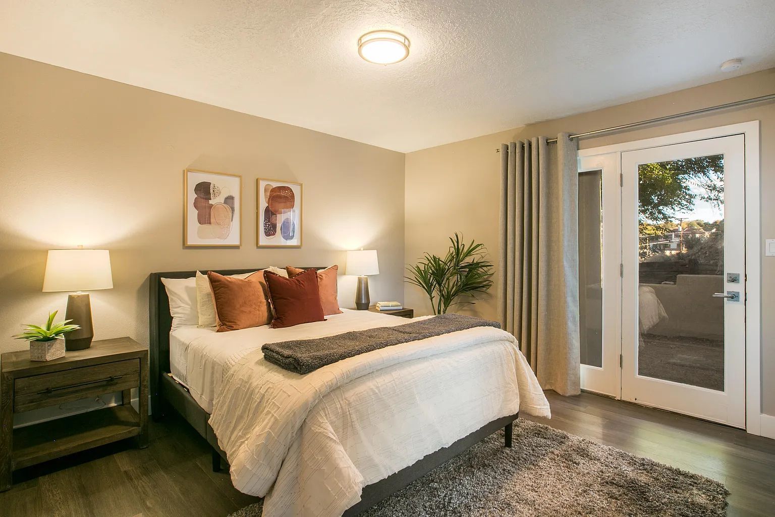 A bedroom with a large bed and a sliding glass door leading to a patio.