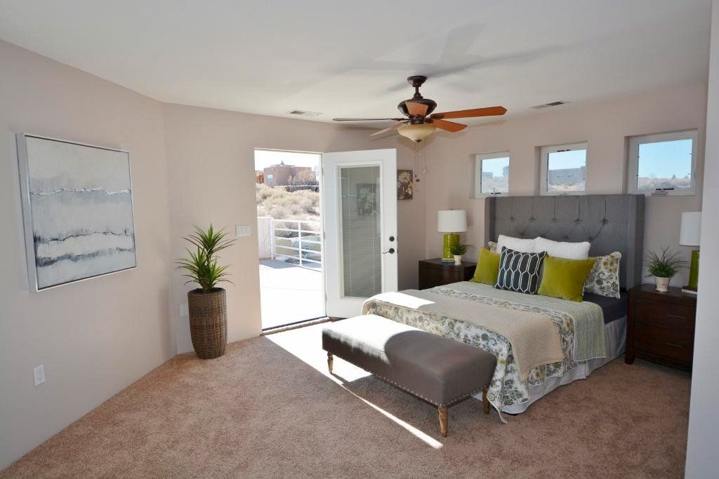 A bedroom with a large bed and a ceiling fan