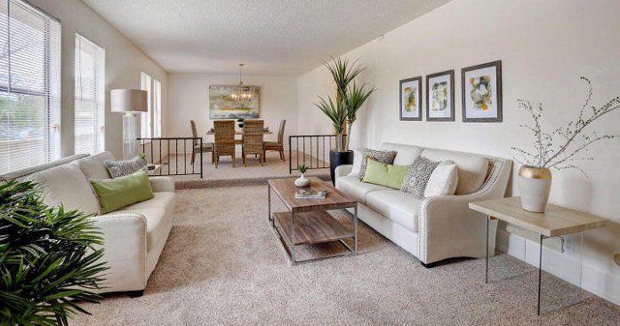 A living room with two couches , a coffee table , and a dining room.