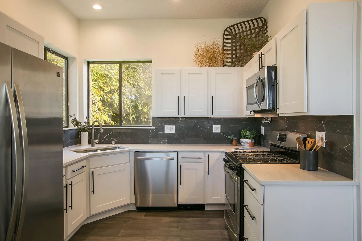 A kitchen with stainless steel appliances and white cabinets