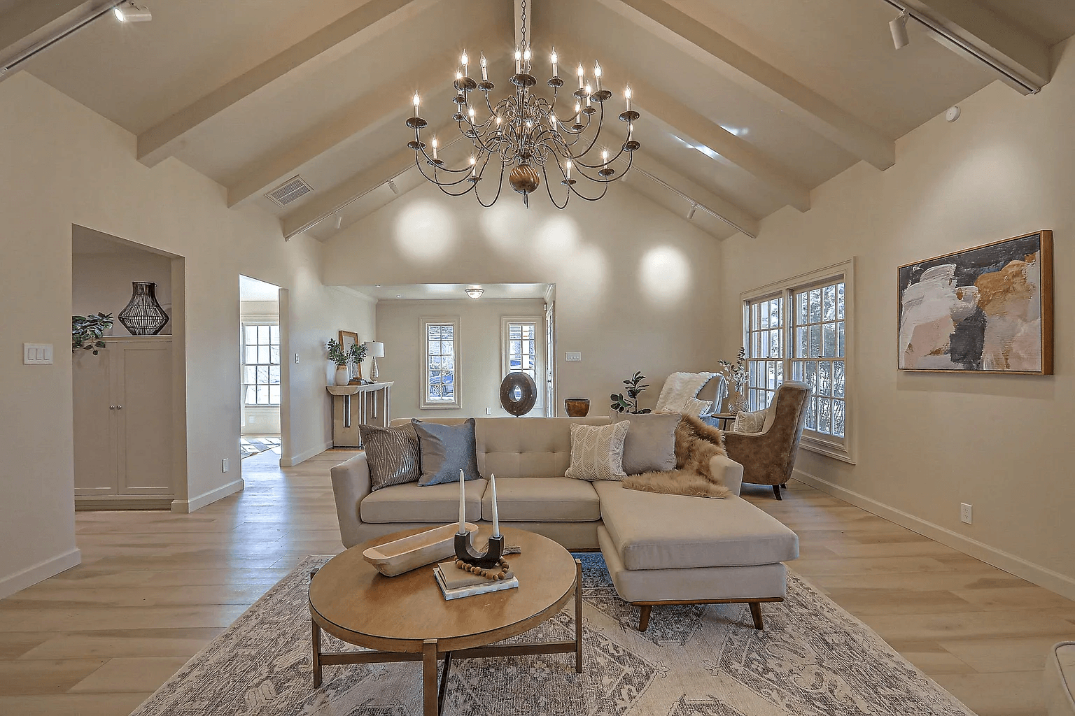 A living room with a couch , coffee table , and chandelier.