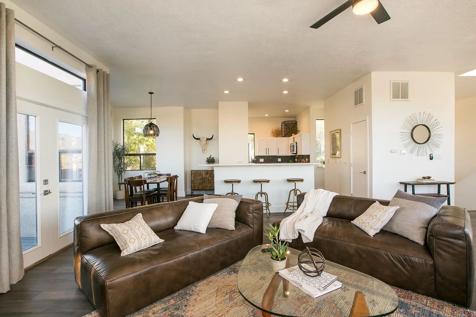 A living room with two couches , a coffee table and a ceiling fan.