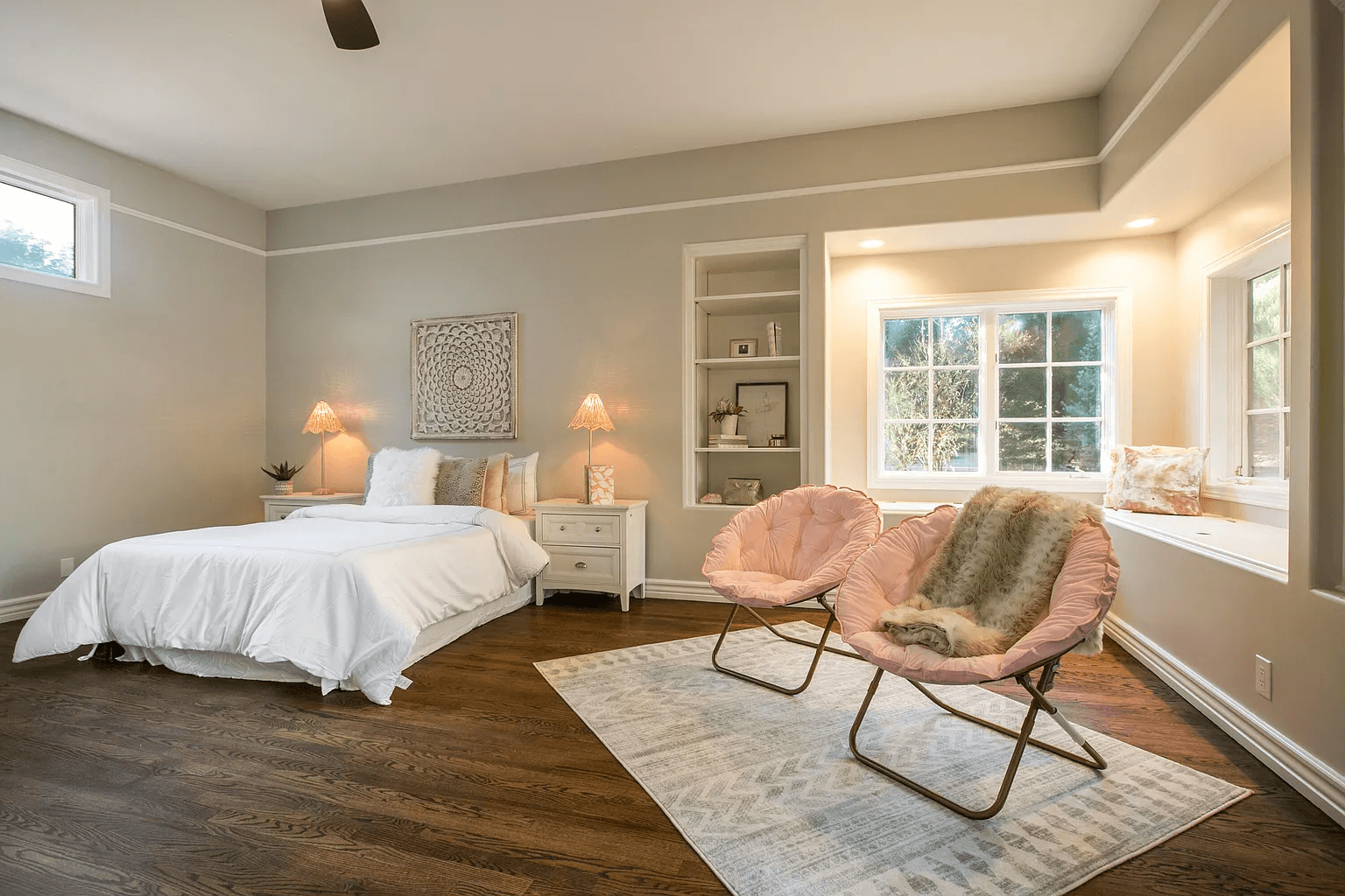 A bedroom with a bed , two chairs and a window.
